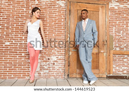 Vintage fashion romantic wedding couple in old urban building. Mixed race.