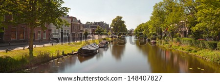 Panoramic photo of dutch city Leiden in summer. Canal and boat and trees.