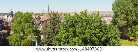 Panoramic photo of roofs and trees of dutch city Leiden in summer.