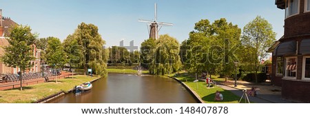 Panoramic photo of dutch city Leiden in summer. Canal and windmill.