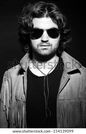Black and white portrait of rock style musician. Wearing sunglasses.