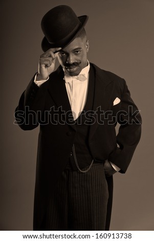 Retro afro american 1900 style man with mustache. Wearing black hat. Taking off his hat.