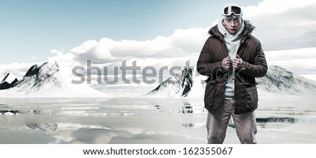 Asian winter fashion man in snow mountain landscape. Wearing woolen hat, jacket and ski glasses.