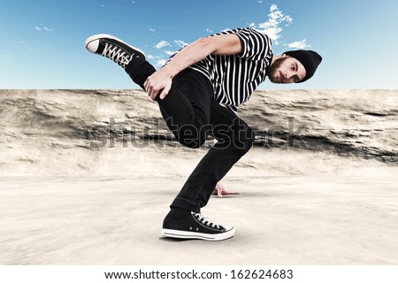 Street dancing man urban fashion with beard. Wearing black woolen hat. Concrete environment.