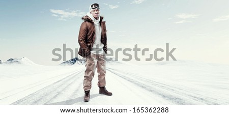 Asian winter sport fashion man in snow mountain landscape. Wearing brown jacket and brown trousers.
