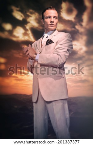 Retro fashion business man wearing white striped suit and tie. Heroic standing in front of rough coastal landscape with stormy sky.