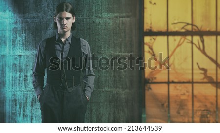 Retro 1900 western fashion man in old warehouse with big window.