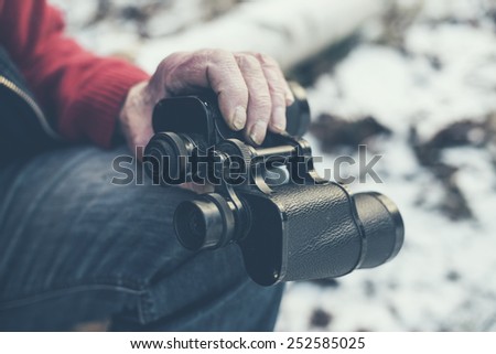 Close up Sitting Old Man Holding a Black Telescope Instrument