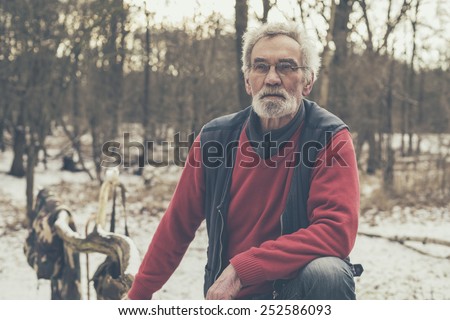 Close up Old Active Man in Casual Jacket Looking Afar Seriously at the Snowed Forest