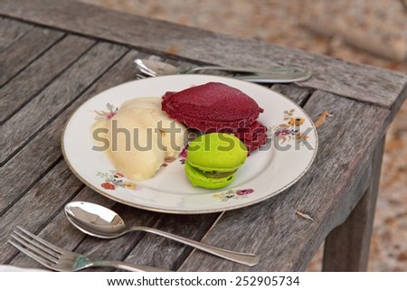 Close up Delicious Pastries on White Round Plate Served on Wooden Table with Spoons and Forks on Side.