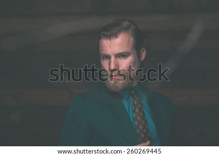 Close up Gorgeous Adult Man with Goatee in Formal Outfit Staring at the Camera on a Wooden Wall Background.