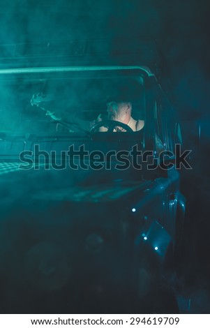 Middle Aged Man Looking at the Rear View Mirror While Driving his Vehicle Alone in the Middle of the Night to Avoid Accidents.