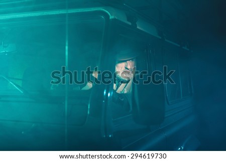 Bearded Middle Aged Guy Looking Into Distance Through the Side Window While Driving his 4x4 Vehicle on a Fuzzy Night.