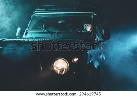 Focused Senior Middle Aged Guy Driving his Vintage 4x4 Vehicle Alone on a Fuzzy Dark Night.
