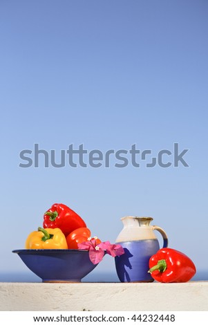 Greek still life with peppers, wine can and colorful pink flower