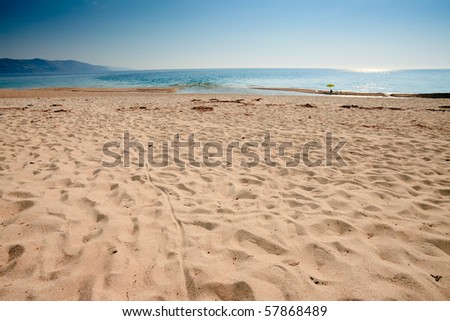 Empty beach with yellow umbrella, Corsica, France