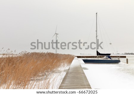 Little harbour in winter with pier and lonely sailing boat, Marken, the Netherlands