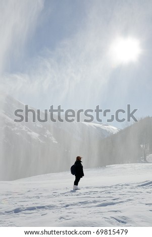 Woman watching a snow spray on mountain