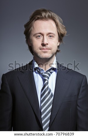 Studio portrait of young business man smiling. Suit and tie.