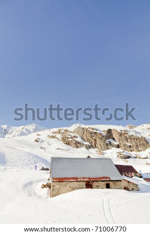 Winter snow mountain landscape with restaurant under blue sky. Chalet. Cottage. Apres ski. Alps. France.
