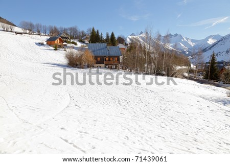 Winter snow mountain landscape with chalets under blue sky. Apartments. Cottages. Wooden houses. Recreational. Alps. France.