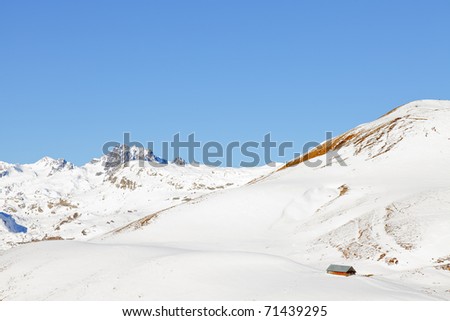 Winter snow mountain landscape with cottage. Blue sky. Sunshine. France. Alps.