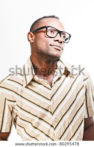 Studio portrait of cool black young man with black glasses and striped retro 70s shirt isolated on white background.