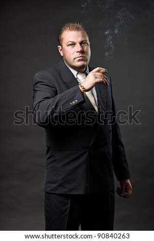 Gangster Mafia Man In Suit With Tie Looking Tough Isolated On Dark