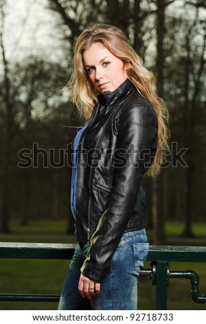 Pretty young woman long blond hair in winter forest wearing black