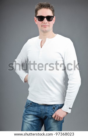 Studio portrait of casual expressive young man brown short hair wearing white shirt and sunglasses isolated on grey background