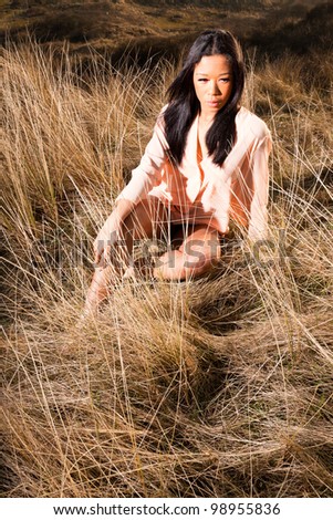 Pretty young black woman posing in dune landscape with clear blue sky. Enjoying outdoors. Wearing ballerina shoes.