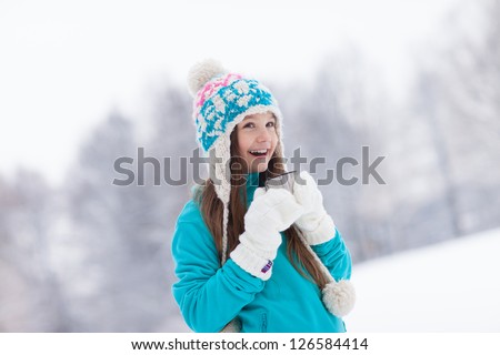 Young girl drinking from thermos cup in winter