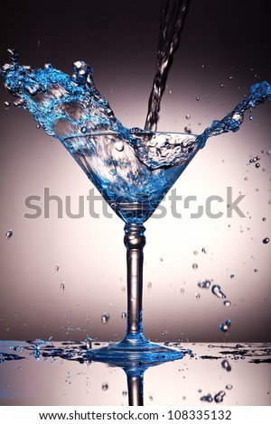 Liquid splash in a martini glass with a blue tint