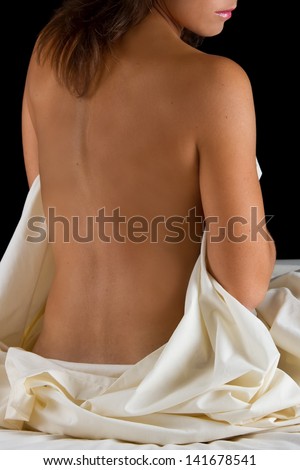 Boudoir woman sit on bed with sheet relaxing and waiting