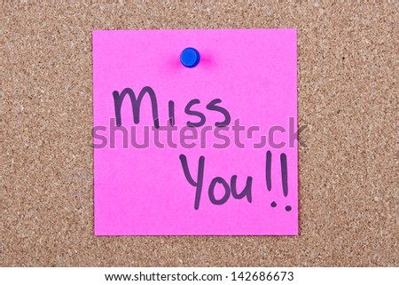 Post it note pink with miss you message on cork