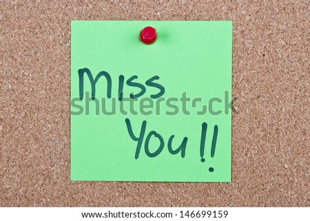 Post it note green with miss you message on cork