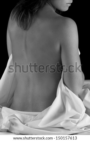 Boudoir woman sit on bed with sheet relaxing and waiting black and white