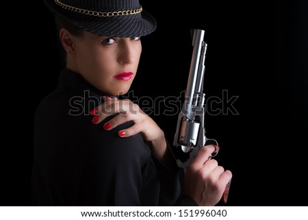 Dangerous woman in black with silver handgun and stylish hat
