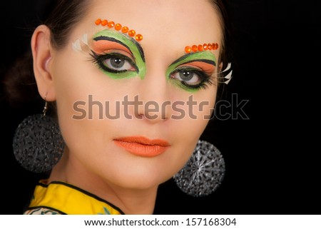 Lovely brunette woman portrait with creative make-up and orange spots