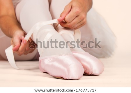 Ballerina sit down on floor to put on slippers prepare  for perform with selective focus