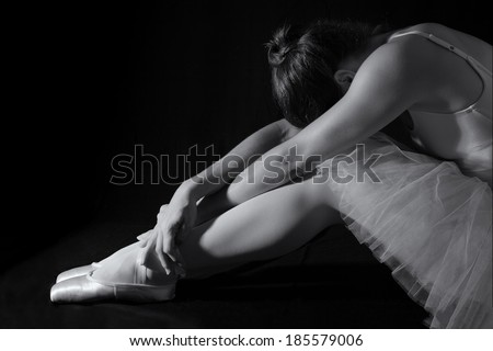 Female dancer sit on floor looking sad in artistic conversion black and white