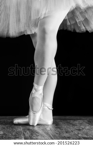 A ballet dancer standing on toes on black background artistic conversion