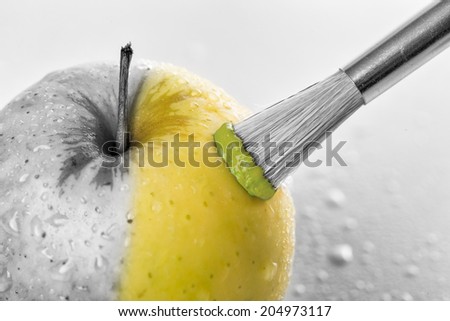 Green apple close-up with water drops being painted on white background