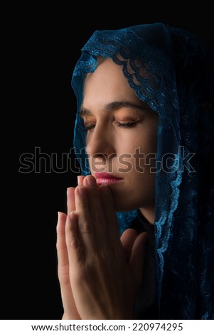 Woman with blue head scarf over her head pray for peace