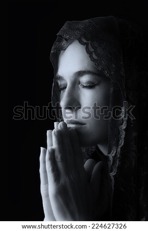 Woman with black head scarf over her head pray for peace