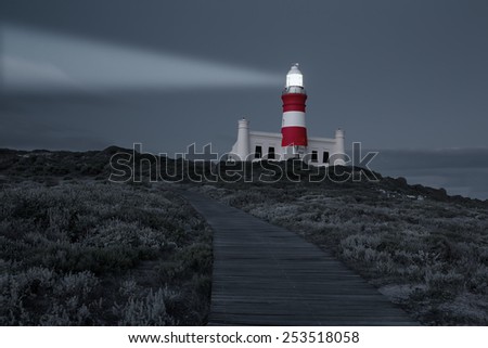 Lighthouse with shining light in darkness with dark blue clouds artistic conversion