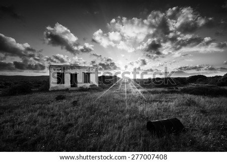 Old small deserted house in field with a cloud sunset landscape artistic conversion