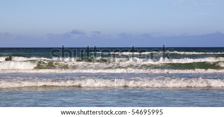 Surf breaking on a beach with a cold front approaching
