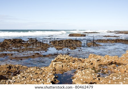 Seascape with waves, rocks and blue sky brown