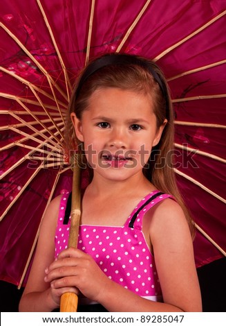 A friendly, small girl holding a pink, chinese umbrella